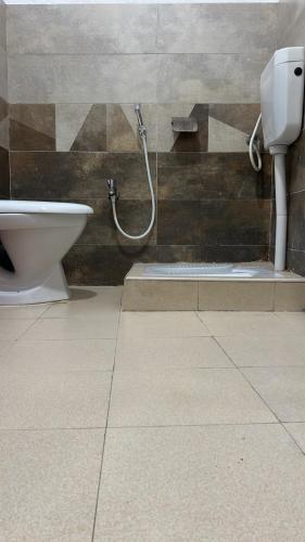 a bathroom with a toilet and a shower at Abu Khalid By MZ Hotels & Restaurant in Mingāora