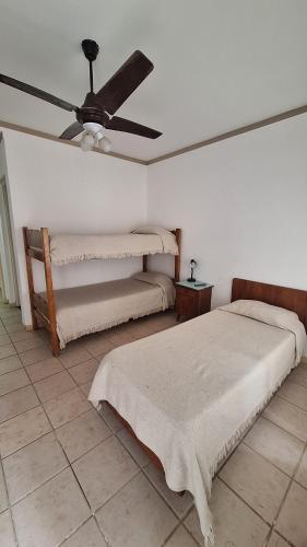 a bedroom with two beds and a ceiling fan at Hotel 7 De Septiembre in San Clemente del Tuyú