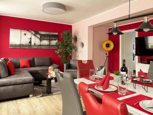 a living room with a red accent wall at Ferienhaus BellaVita - mit großem eingezäuntem Garten - Infrarotsauna - 3 Hunde willkommen - Badesee 800m entfernt in Walkenried