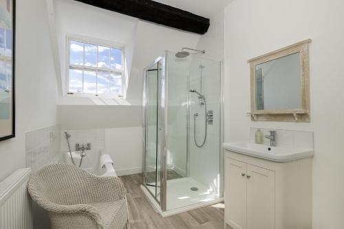 a white bathroom with a shower and a sink at The Haven in Chipping Norton