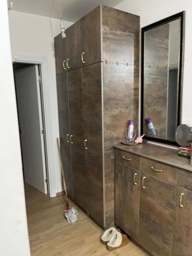 a bathroom with a large wooden cabinet and a mirror at Stan na dan Ub in Ub