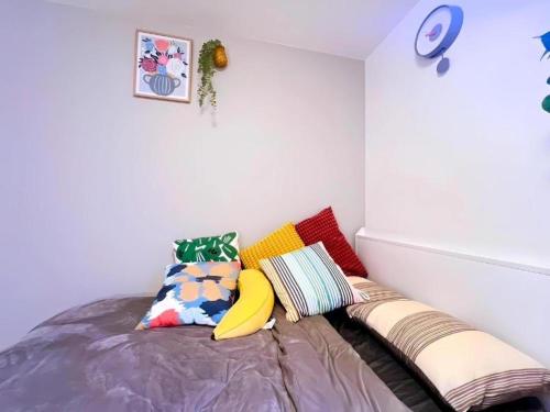 a bedroom with a bed with colorful pillows at Toyo Yoyoginumi in Tokyo