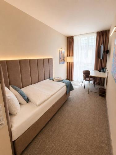 a hotel room with a large bed and a desk at Oysters & Bubbles Gastro Rooms Rynek Square in Poznań