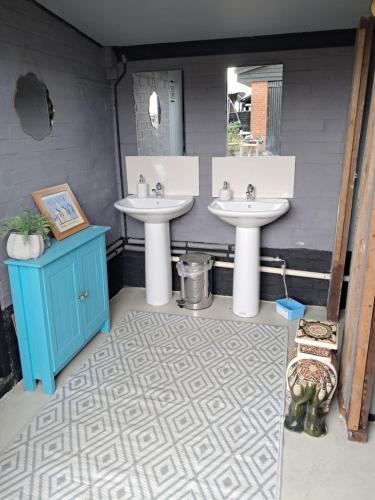 a bathroom with two sinks and a blue cabinet at The Old Waterworks - Saturn 6m bell tent in Clare