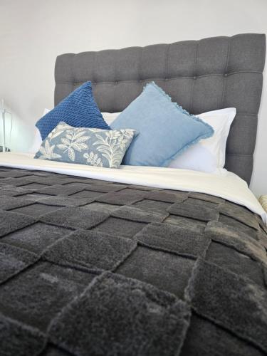 a bed with blue and white pillows on it at Rosa's Self-catering Unit 2 in Springbok