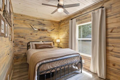 a bedroom with a bed in a room with wooden walls at Rustic Retreat — Easy Access, Peaceful Setting, Close to Everything in Sevierville