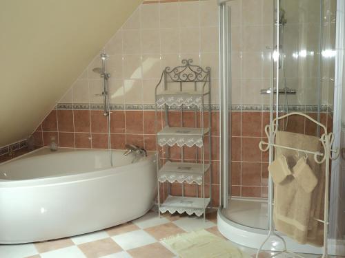 a bathroom with a tub and a shower and a toilet at Le Logis Du Mesnil 
