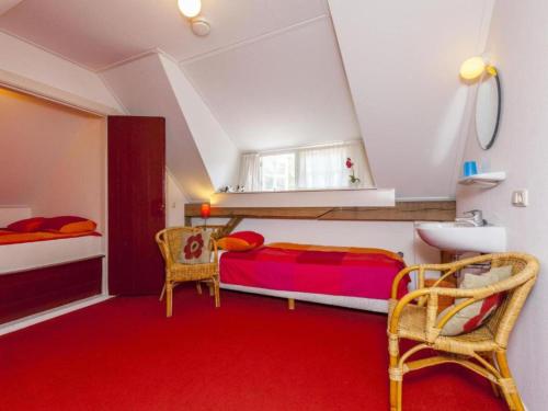 a bedroom with two beds and a red carpet at Hytte in Balkbrug