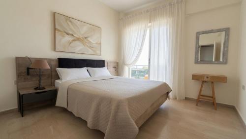 a bedroom with a large bed and a window at Kineta Prime Suites No3 in Kineta