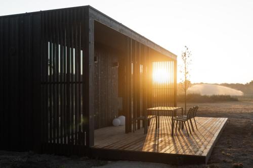 a building with a table and chairs on a deck at Eco by Nature - De Adem - in Heythuysen