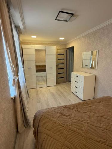 a bedroom with a bed and a dresser and a closet at Njoy in Jermuk