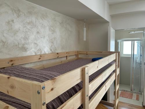 a wooden bunk bed in a room with a shower at movida beach in Bari