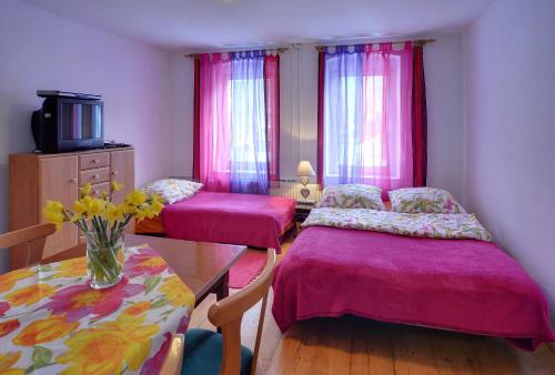 a room with two beds and a table with a vase of flowers at Biotanika in Michałkowa