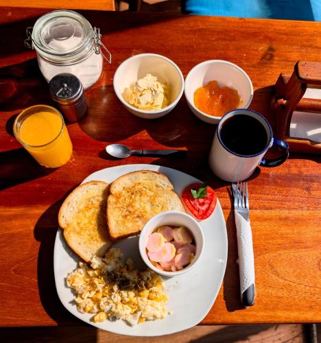 a plate of breakfast food with eggs and toast on a table at Lobo Hostel La Paz in La Paz