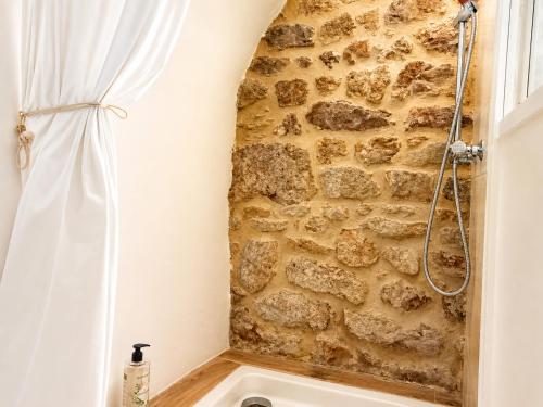 a bathroom with a stone wall and a shower at "La Voûte de Pierre" Gîte indépendant in Saint-Cyr