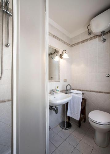 a white bathroom with a toilet and a sink at Affittacamere Chiti Melania in San Gimignano