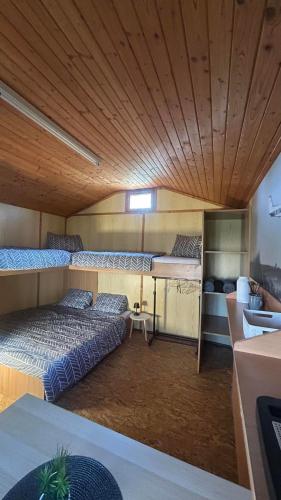 a room with two beds in it with a wooden ceiling at Útulné dřevěné chatky Kunovice in Kunowitz