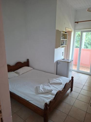 a bedroom with a bed and a kitchen with a window at Villa Magdalena studios in Ágios Ioánnis