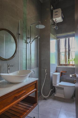 a bathroom with a sink and a toilet and a mirror at DQ Peaceful Villa in Thôn Dương Xuân Hạ
