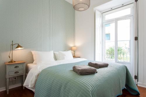 a bedroom with a bed with two towels on it at Bairro Alto Viewpoint Flat in Lisbon