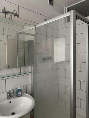 a white bathroom with a sink and a shower at Comfortable Private Room in a Prime Location! HBF in Wolfsburg