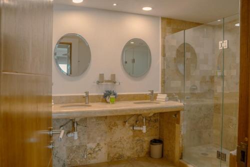 a bathroom with a sink and two mirrors at NITTA 209 Elegant Apartment - Partial Sea Views in Nuevo Nayarit