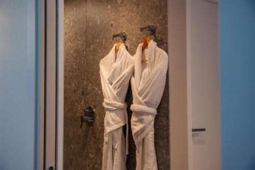 three towels are hanging on a wall in a bathroom at Best Western Plus Metz Technopole in Metz