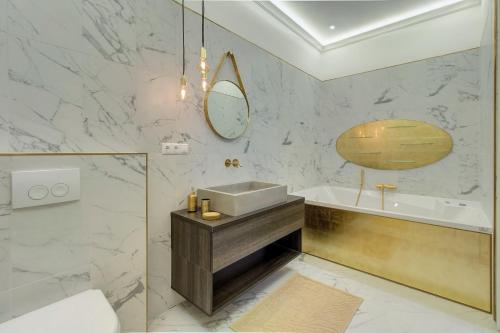 a bathroom with a sink and a tub and a mirror at Count Zrinyi Basilica Luxurious Residence in Budapest