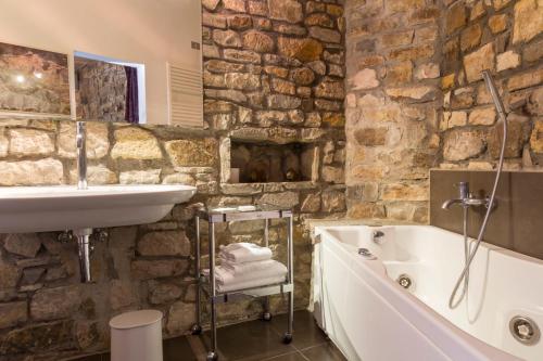 フィレンツェにあるFattoria Il Milione Agriturismoの石壁のバスルーム(バスタブ、シンク付)