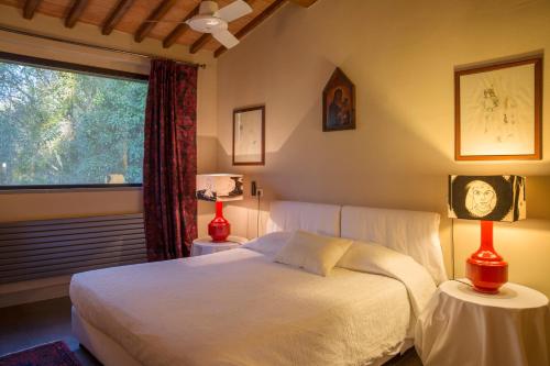 フィレンツェにあるFattoria Il Milione Agriturismoの白いベッドと窓のある寝室