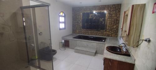 a bathroom with a shower and a sink at Arraial do Cabo - Suite master in Arraial do Cabo