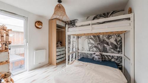 a bedroom with a bunk bed and a window at Les clos des Aviateurs in Strasbourg