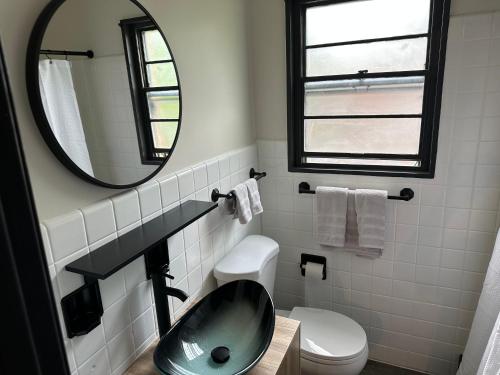 a bathroom with a sink and a mirror and a toilet at Keyes Motel in Arlington Heights