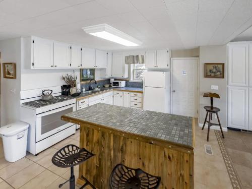 a kitchen with white cabinets and a wooden counter top at MTN Meadow Retreat near PC in Peoa