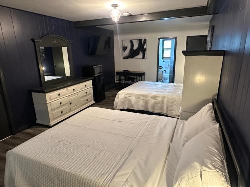 a bedroom with two beds and a dresser and a mirror at Keyes Motel in Arlington Heights