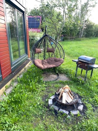 a backyard with a swing and a fire pit at Bedugnės Namelis in Vilnius