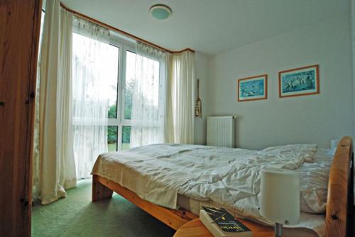 a bedroom with a bed and a large window at Fährhof 6b EG in Wiek auf Rügen