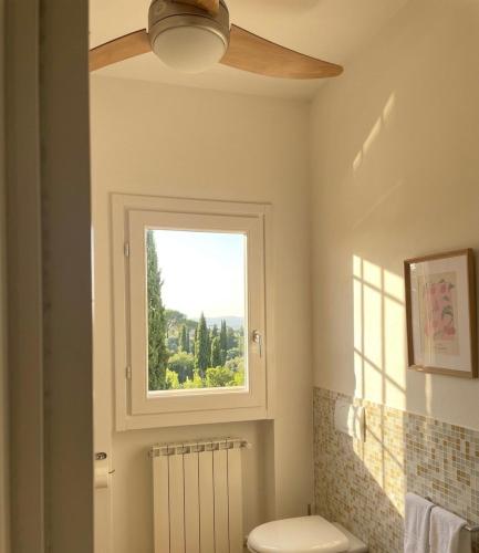 a bathroom with a ceiling fan and a window at Poggio Madonna in Campagnatico