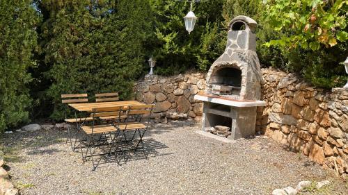 a wooden table and chairs next to a stone oven at Villa La Solana Rocabella in El Chorro