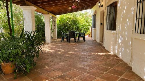 a patio with a table and chairs on a house at Villa La Solana Rocabella in El Chorro