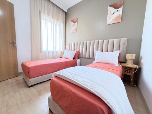 a bedroom with two beds and a window at Riad Marrakech, oasis apartment in Marrakesh