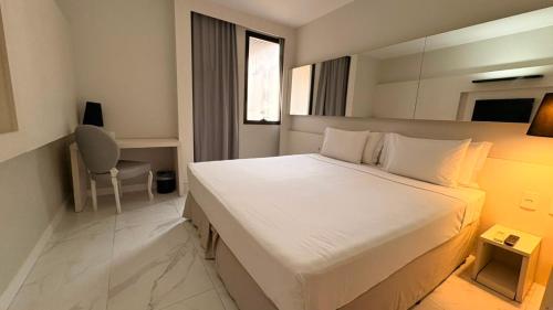 a bedroom with a large white bed and a chair at Aera Rio de Janeiro Copacabana in Rio de Janeiro