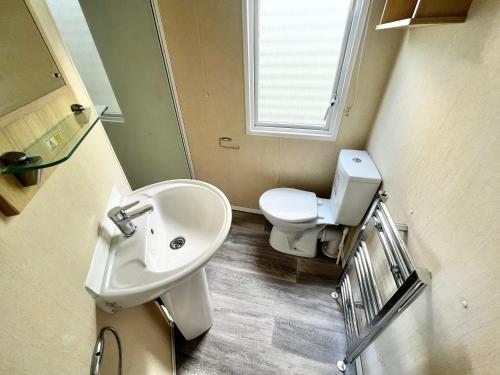 a bathroom with a sink and a toilet at california cliffs caravan 2 dunlin in Scratby