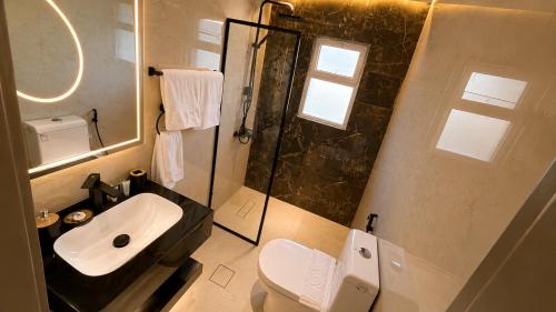 a bathroom with a toilet and a sink and a shower at Sama Al Sweifieh - سما الصويفية in Amman