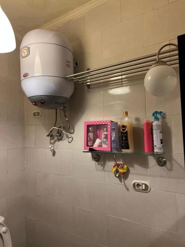 a bathroom with a hair dryer and a light on the wall at Cozy chalet in El Alamein