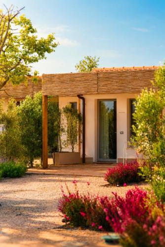 a small house with flowers in front of it at Radicata Tuscany Relais in Albinia