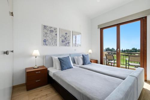 a bedroom with two beds and a large window at Modern Villa HG08 Pyrinas with Amazing Golf Views, in heart of Aphrodite Hills in Kouklia