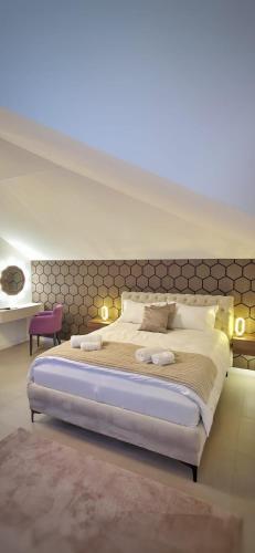 a bedroom with a large bed with a large headboard at Jezero Rudanka in Doboj