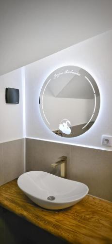 a bathroom sink with a round mirror above it at Jezero Rudanka in Doboj