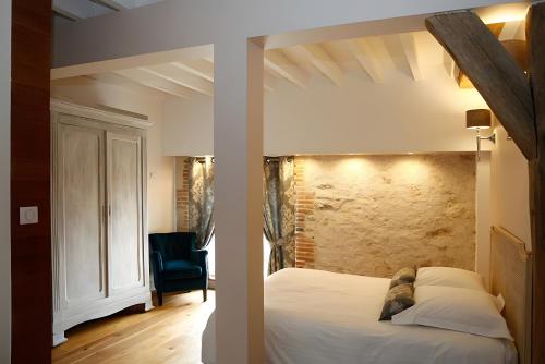two images of a bedroom with a bed and a chair at Gîte De La Crayère in Gionges